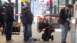 Polizisten untersuchen am Hauptbahnhof in Bonn Reste einer Tasche
