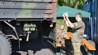 Bundeswehr bei Hilfsarbeiten, zwei Soldaten navigieren Lkw