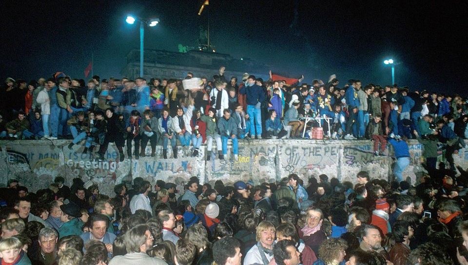 Viele Berliner sitzen und stehen in den Tagen  und Naechten nach dem "Mauerfall"  (09.11.1989)  auf der Mauer.