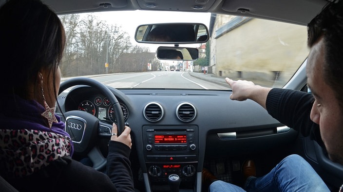 Junge Frau mit Fahrlehrer