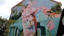 Das Graffitti von Julia Benz zeigt eine verschleierte Frau auf einer Giebelwand