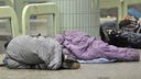 Obdachlose in Schlafsäcke gehüllt