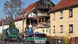 Polizeifahrzeuge stehen am Mittwoch (09.11.2011) vor einem durch eine Explosion zerstörten Haus in Zwickau.