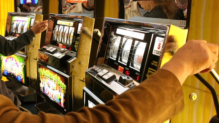 Mann spielt an einem Spielautomaten
