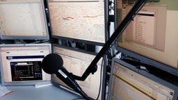 Am Arbeitsplatz im WDR-Verkehrsstudio stehen viele Monitore und ein Mikrofon