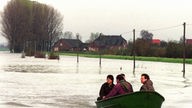 Förster fahren mit einem Boot die Hochwassergrenze bei Grietherort am Niederrhein ab, um nach im Wasser eingeschlossenem Wild zu suchen, 1998