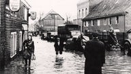 Menschen waten durch das Hochwasser der Wupper in Opladen, 1946