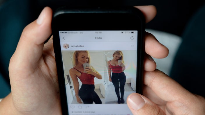 Das Display eines Smartphones zeigt das Instagram-Profil von Nutzerin Amalie Lee, die an einer Essstörung leidet