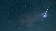 Eine Sternschnuppe leuchtet  über dem Sternbild "Großer Wagen"