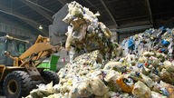 Wiederverwertbarer Abfall wird in einer Müllsortieranlage der Firma Trienekens im Sortierwerk Krefeld mit einem Bagger umgeschichtet.
